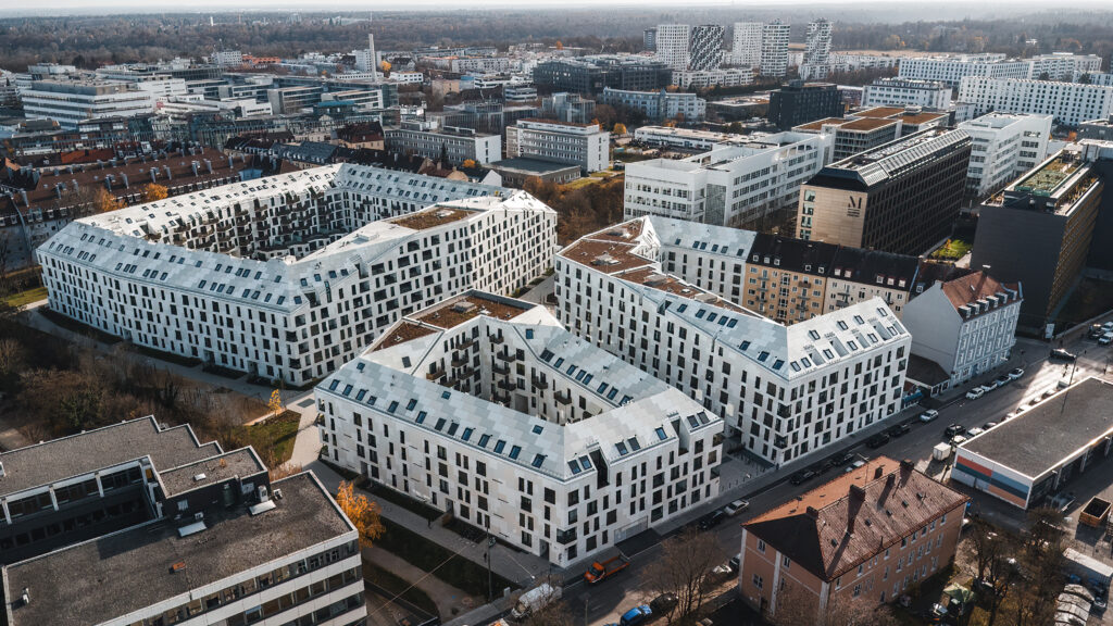 Luftaufnahme von modernen Wohngebäuden in einer städtischen Umgebung mit verschiedenen Architekturstilen.